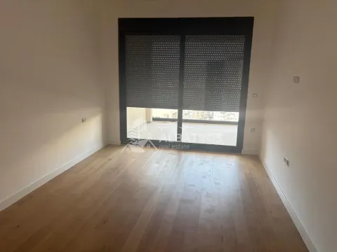Prazna soba sa parketom i velikim balkonskim vratima sa roletnama. - image 4