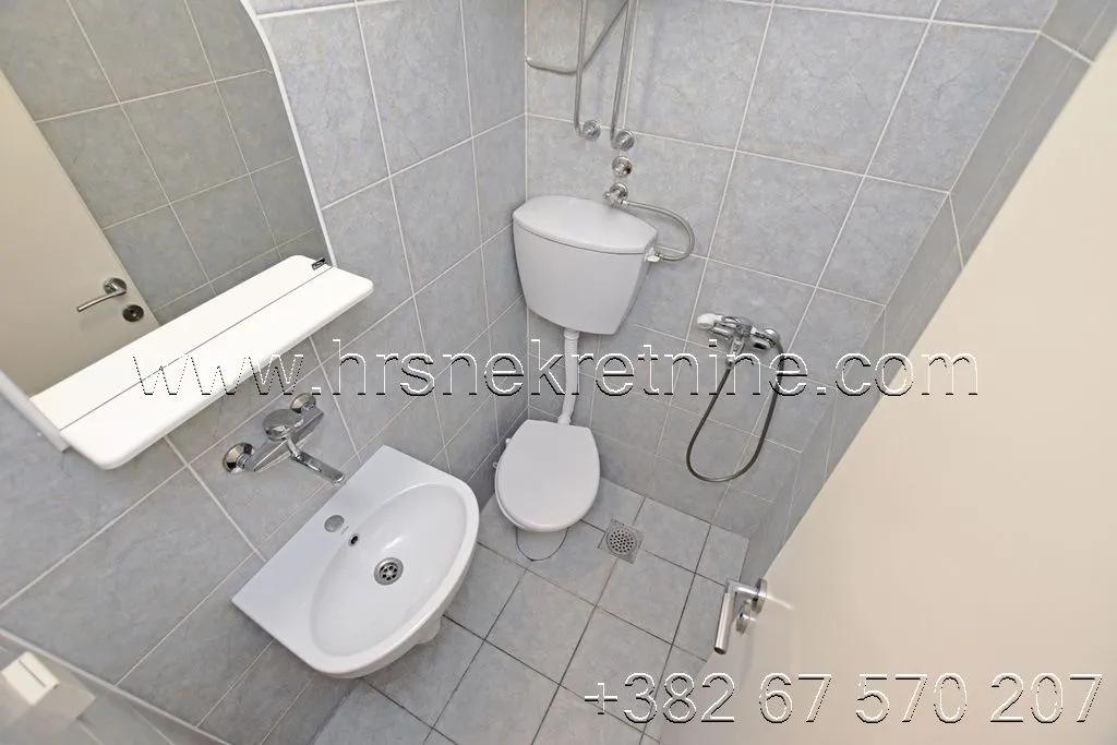 Smaller bathroom with tiles, a sink, and a toilet.