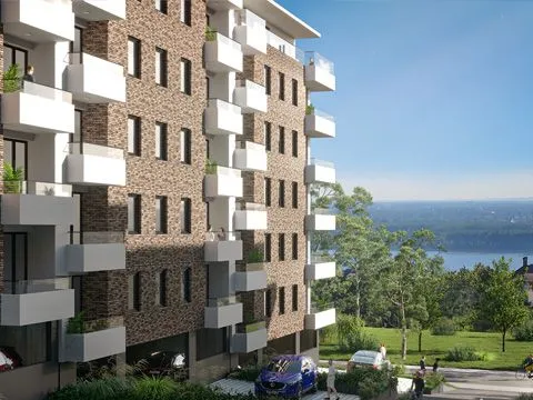 Spoljašnji izgled moderne stambene zgrade sa terasama i pogledom na prirodu.