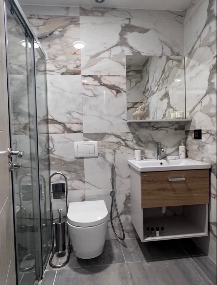 Moderne kupatilo sa tuš kabinom, umivaonikom i wc šoljom.