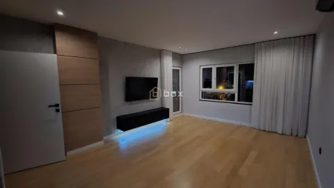 Dnevna soba sa drvenim podom, TV jedinicom i velikim prozorima. - image 2