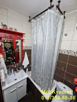 Kupatilo opremljeno umivaonikom, kadom sa zavesom i toaletom. - image 4