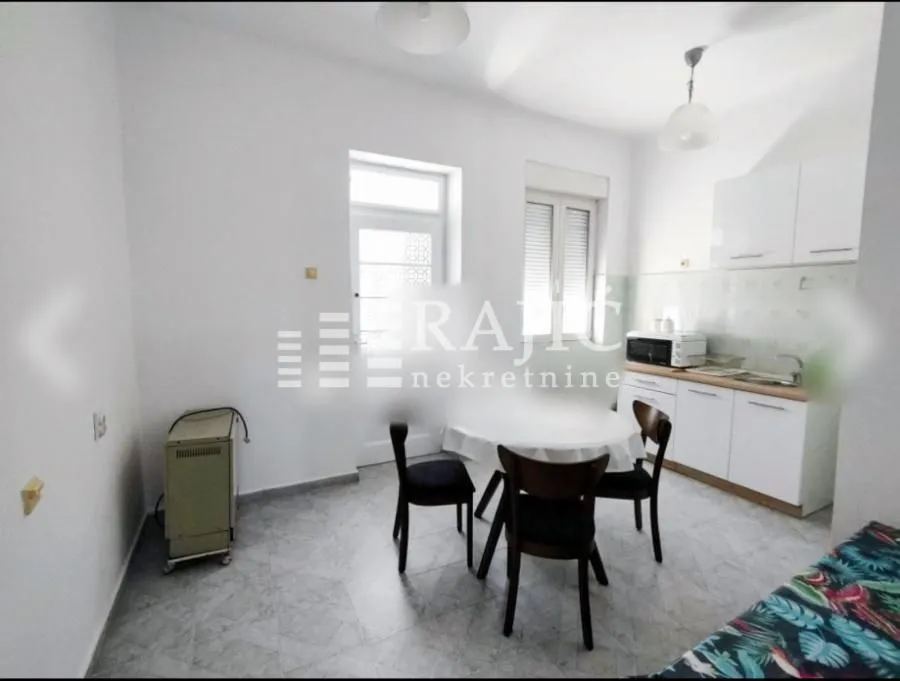 Small kitchen with a dining table and white cabinets.