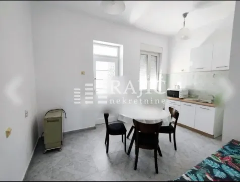 Small kitchen with a dining table and white cabinets. - image 7