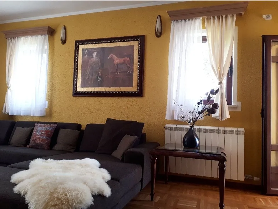A living room with yellow walls and a dark sectional sofa.