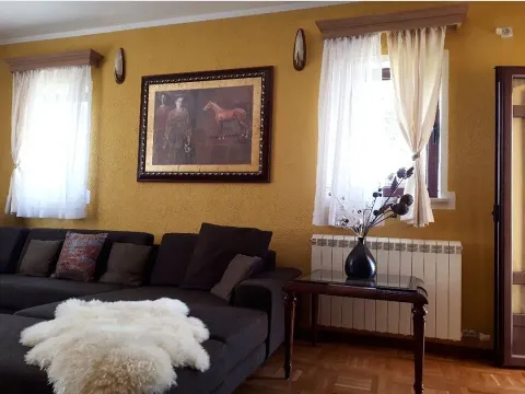 A living room with yellow walls and a dark sectional sofa. - image 4