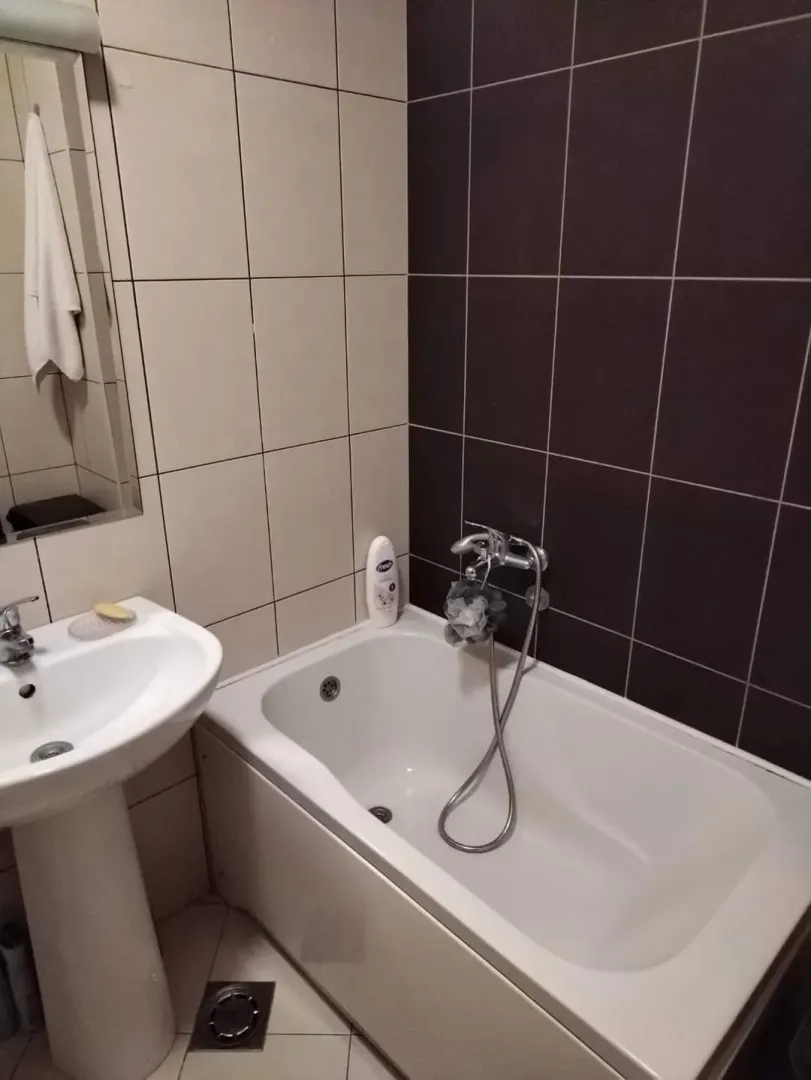 Bathroom equipped with a bathtub, sink, and mirror.