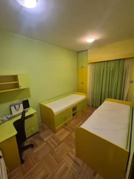 Dječija soba sa dva kreveta, radnim stolom i garderoberom u zelenim i žutim tonovima. - image 10