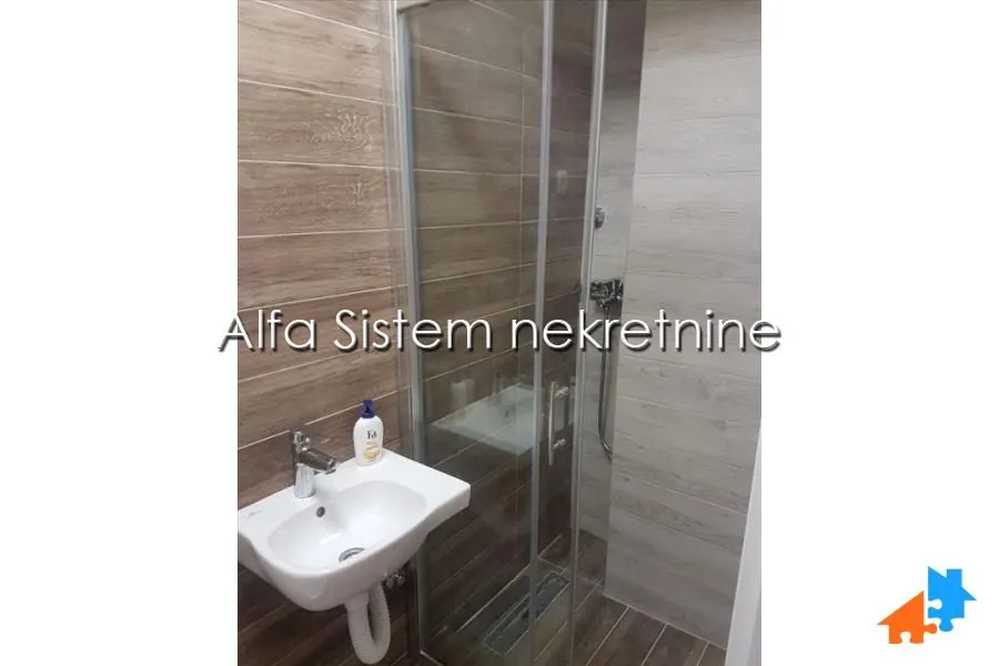 Kupatilo sa tuš kabinom i umivaonikom.