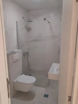 Modern bathroom with a shower cabin and wall-hung toilet. - image 5