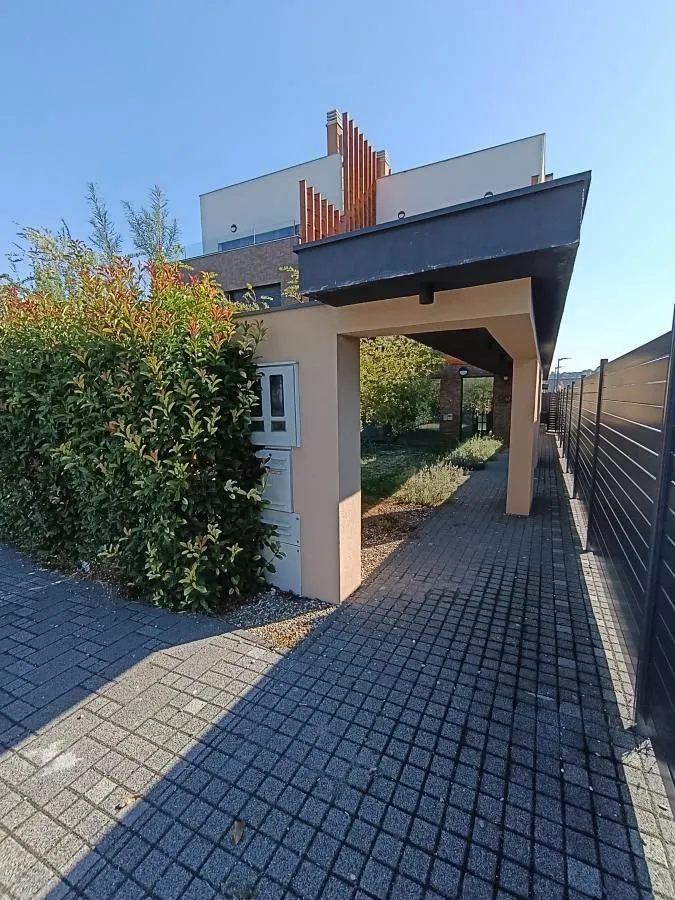 Building entrance with a paved walkway and landscaped courtyard.