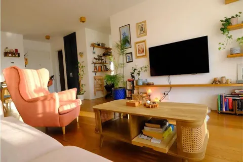 Cozy living room with seating furniture, wooden coffee table, and wall-mounted television. - image 10
