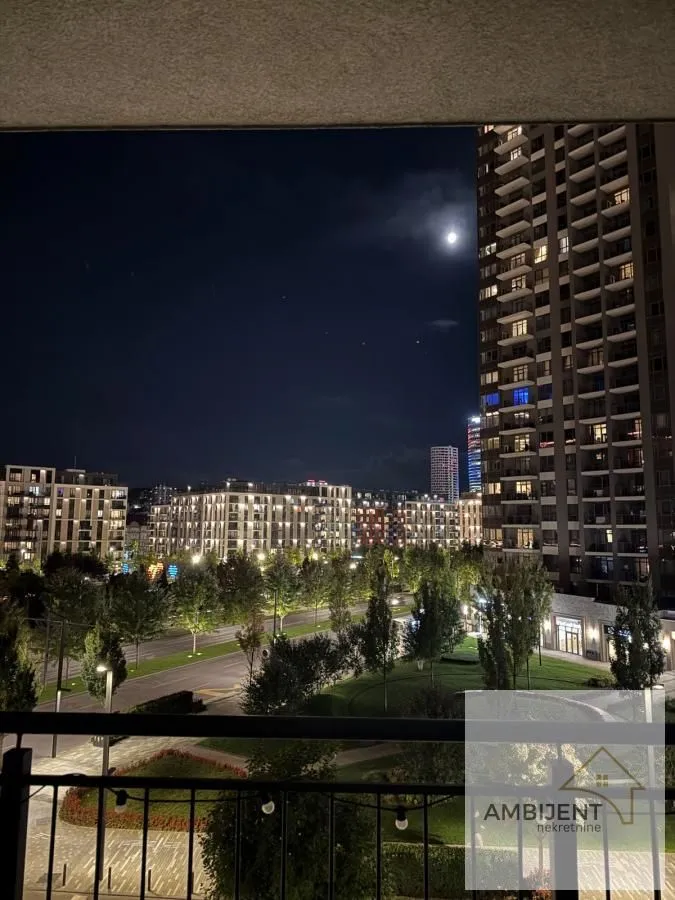 Noćni pogled sa terase na grad i osvetljene ulice.