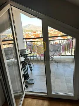 Manji popločani balkon sa sušilom za veš i pogledom na grad. - image 4