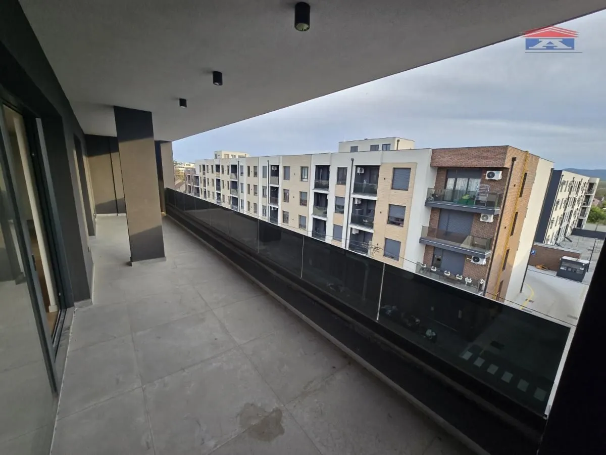 Spacious covered balcony with a view of surrounding residential buildings.