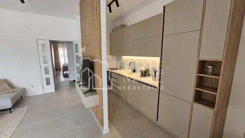 Moderna kuhinja povezana sa dnevnim boravkom u svijetlim tonovima. - image 4
