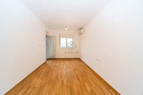 Prazna soba sa bijelim zidovima, drvenim parketom i izlazom na terasu. - image 4