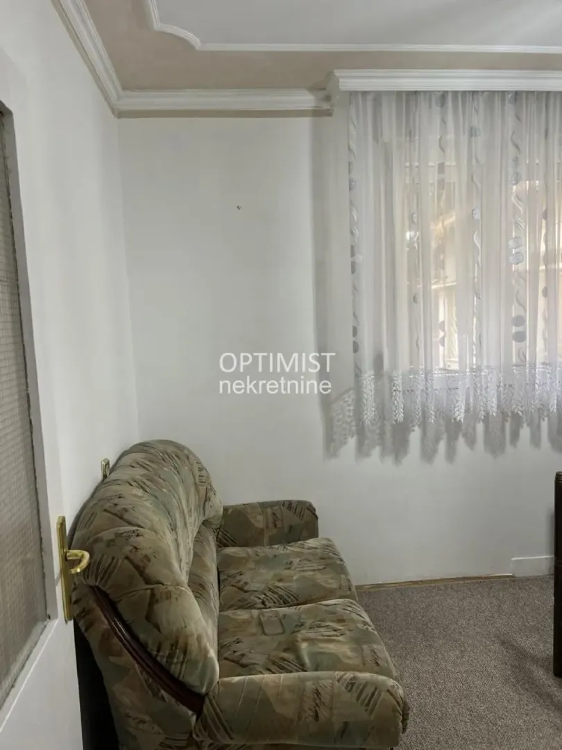 Smaller section of the living room with a sofa and a window.