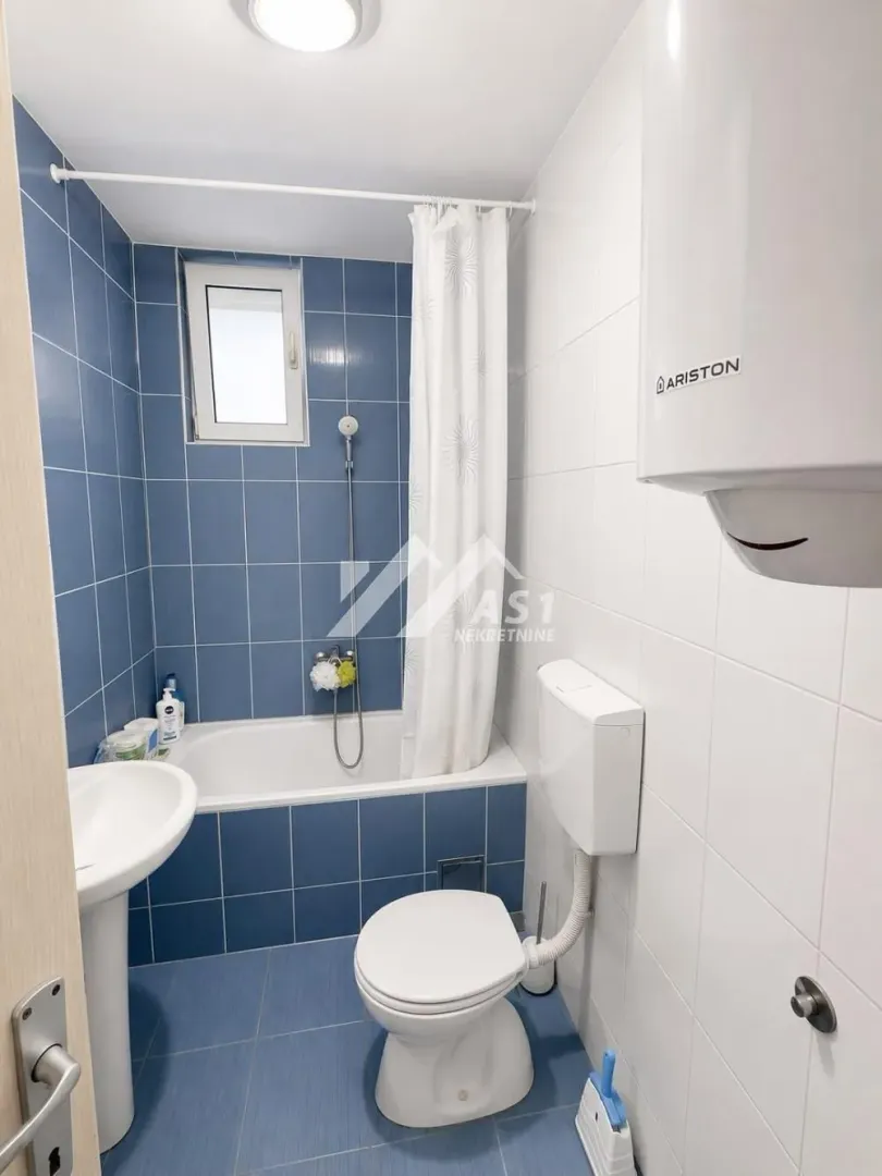 Compact bathroom with a bathtub, washbasin, and toilet.