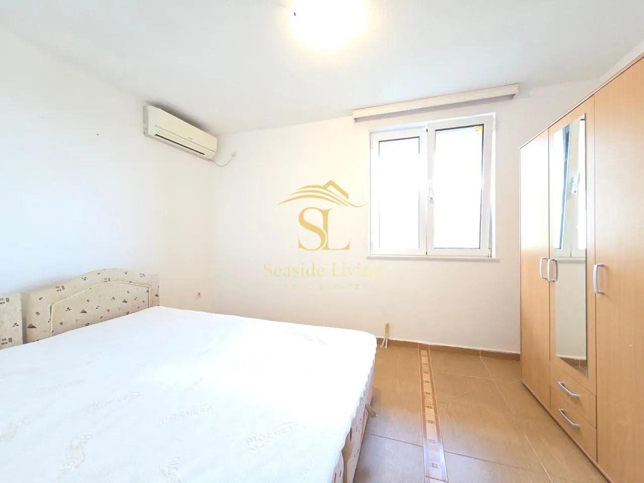 Furnished bedroom with a double bed, wardrobe, and air conditioning.