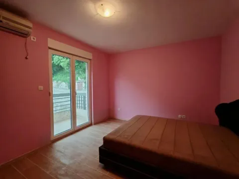 Spavaća soba sa roze zidovima, krevetom i balkonskim vratima. - image 10