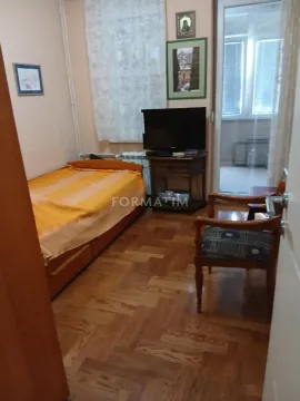 Manja spavaća soba sa krevetom, televizorom i izlazom na terasu. - image 5