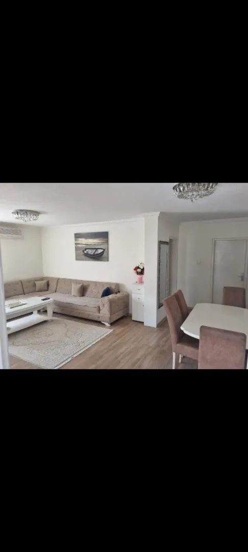 Bright living room with a sectional sofa and a dining table.