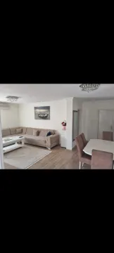 Bright living room with a sectional sofa and a dining table. - image 13