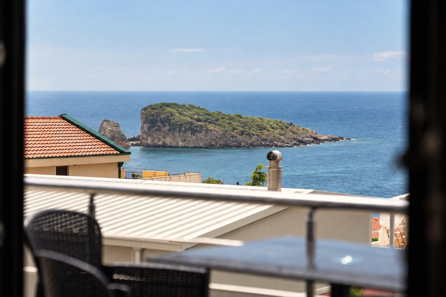Pogled na more i ostrvo kroz prozor sa terase.