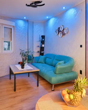 Living room with a turquoise sofa and a dining table. - image 3