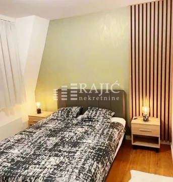 Furnished bedroom with a double bed and decorative wooden panels. - image 3