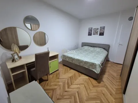 Nameštena spavaća soba sa bračnim krevetom, radnim stolom i parketom na podu. - image 7