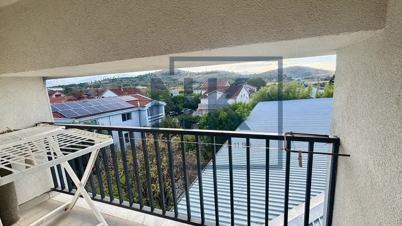Pogled sa balkona na okolne kuće i brda.