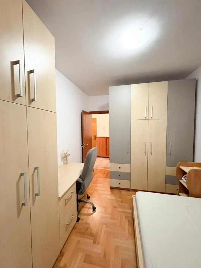 Namještena spavaća soba sa radnim stolom i garderoberom.