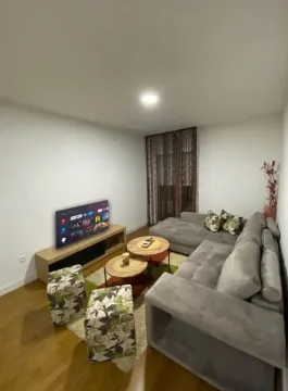 Living room with a sectional sofa, TV, and coffee table. - image 3