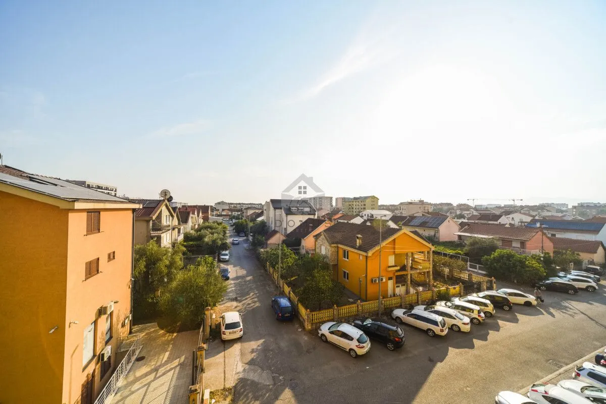 View from the apartment overlooking the street and surrounding houses with parking.