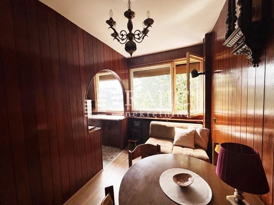 Living room with wood wall paneling and a dining table.