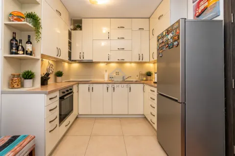 Manja svijetla kuhinja u obliku slova U sa elementima bež boje i frižiderom. - image 4