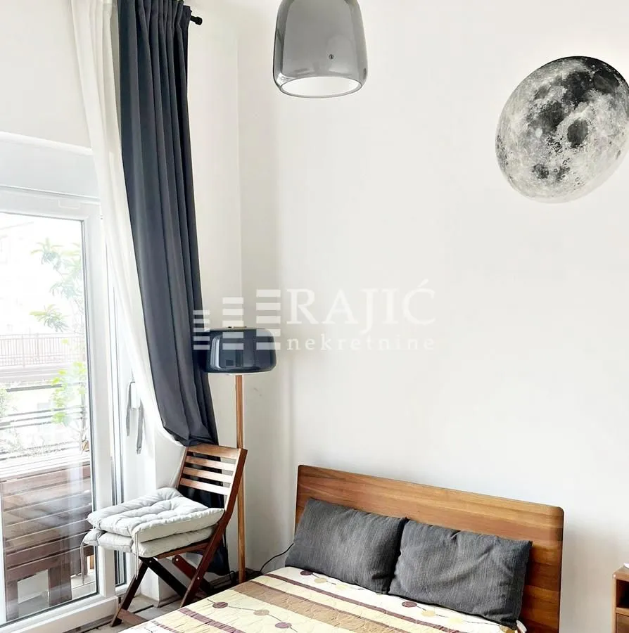 Bright bedroom with a wooden bed and access to the terrace.