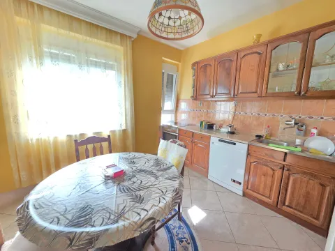 Kitchen with wooden cabinetry and a dining table by the window. - image 9