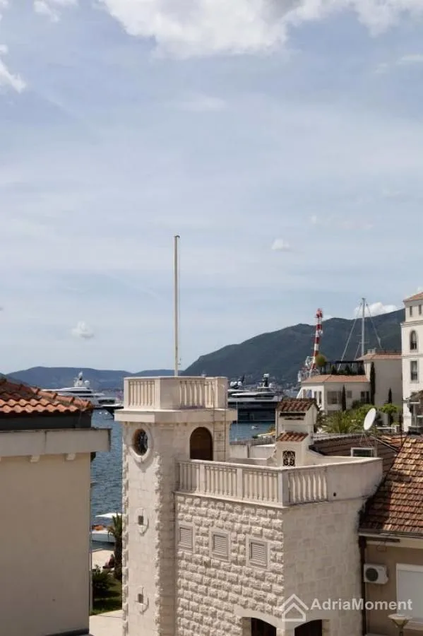 Pogled sa terase na grad, marinu i planine u pozadini.