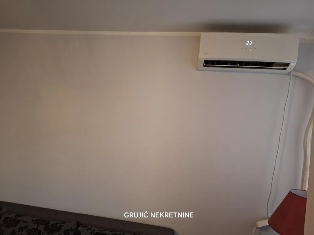 Pogled na zid sa montiranim klima uređajem u prostoriji.