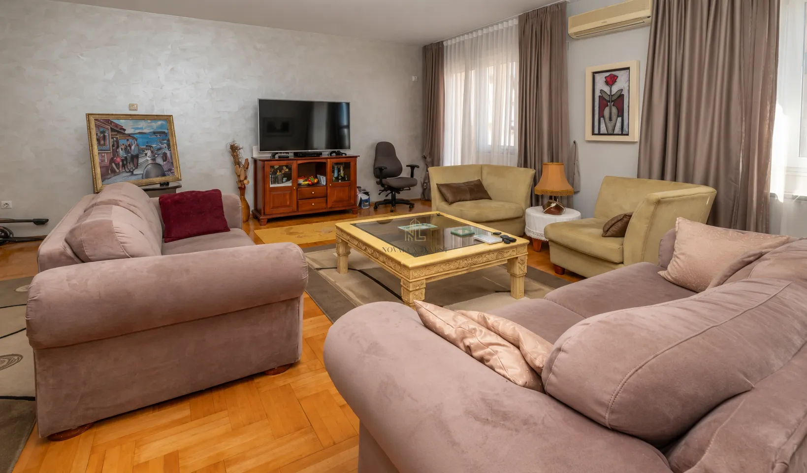 Spacious living room with a sofa set, coffee table, and television.
