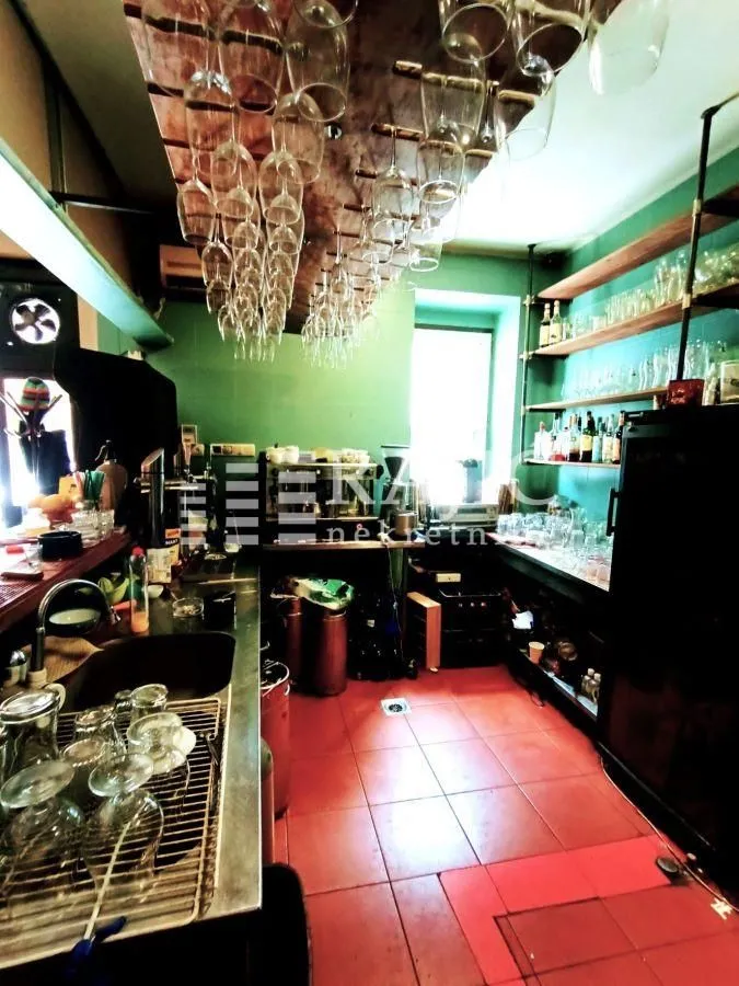 Interior of a commercial hospitality venue with a bar counter and hanging glasses.