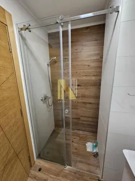 Moderna tuš kabina sa staklenim paravanom i keramičkim pločicama u imitaciji drveta. - image 7