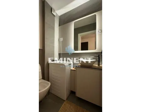 Modernly equipped bathroom with a washbasin, backlit mirror, and washing machine. - image 14