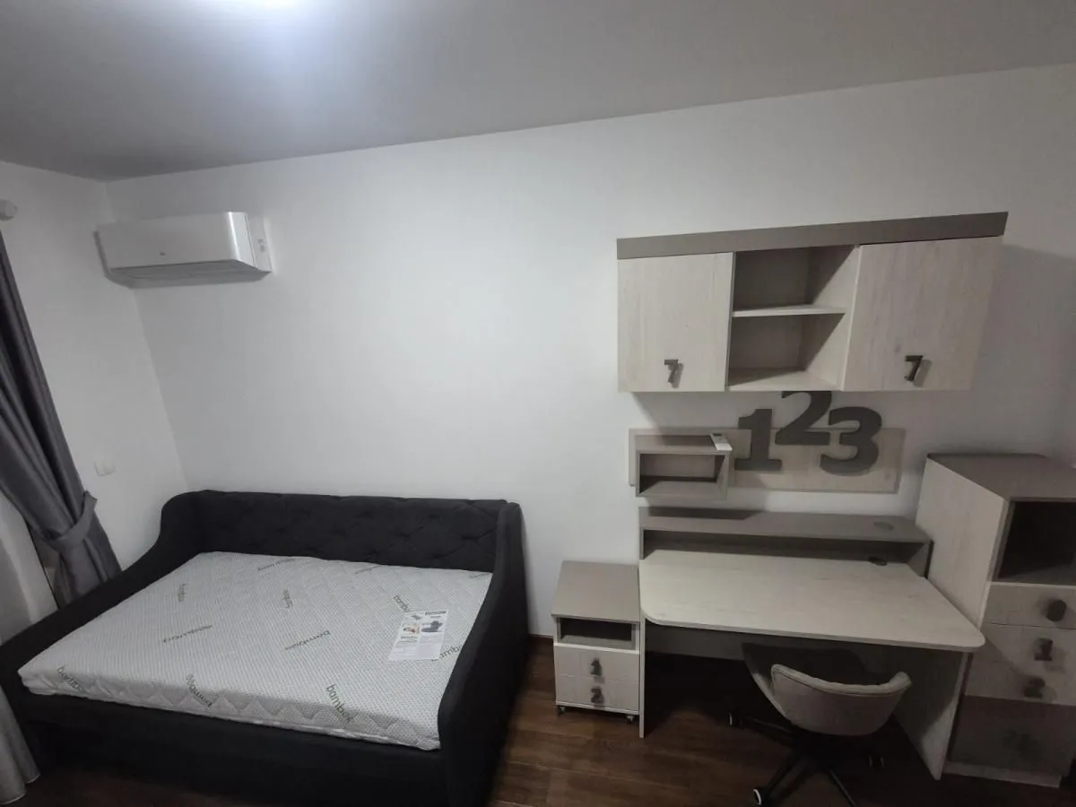 Dječja soba sa krevetom, radnim stolom i zidnim elementima.