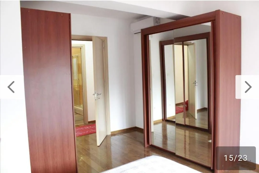 Bedroom with a large wooden wardrobe with a mirror.