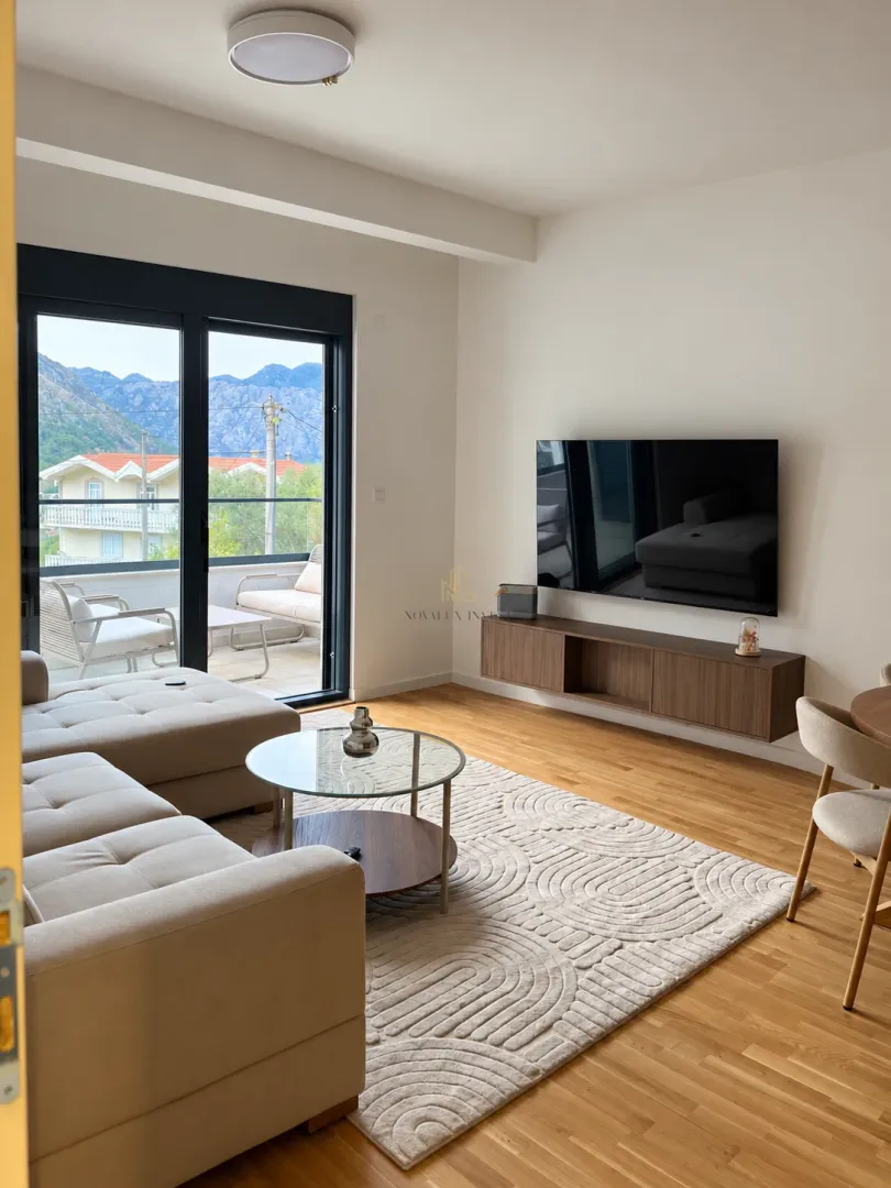 Living room with sofa, TV and access to the terrace with mountain view.