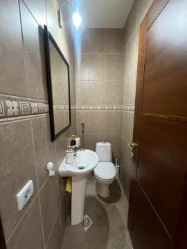 A small restroom with a sink, a mirror, and a toilet. - image 16